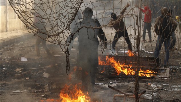 Des protestataires jettent des pierres aux policiers lors d'une manifestation à la place Tahrir samedi. Des protestataires jettent des pierres aux policiers lors d'une manifestation à la place Tahrir samedi.