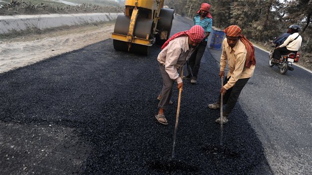 Des travailleurs indiens asphaltent une route. Des travailleurs indiens asphaltent une route.