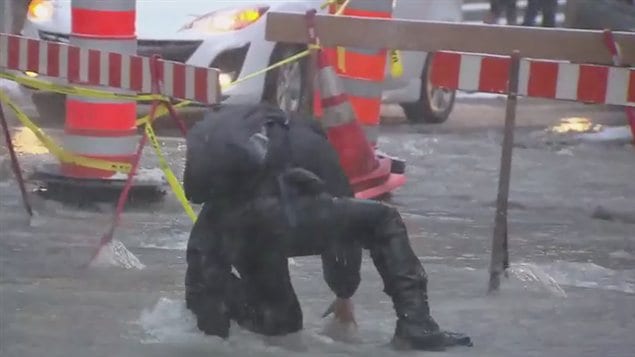 Ce piéton a eu du mal à se frayer un chemin au milieu de la rue inondée. Ce piéton a eu du mal à se frayer un chemin au milieu de la rue inondée.