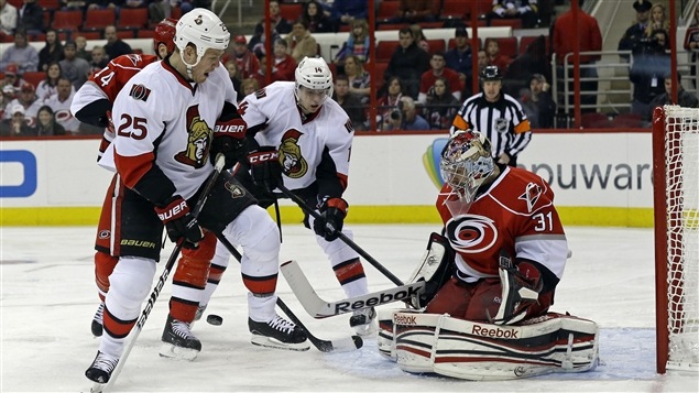 Dan Ellis des Hurricanes de la Caroline stoppe le tir de Chris Neil des Sénateurs d’Ottawa. Dan Ellis des Hurricanes de la Caroline stoppe le tir de Chris Neil des Sénateurs d’Ottawa.