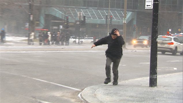 Une puissante bourrasque de vent malmène un piéton au centre-ville de Montréal. Une puissante bourrasque de vent malmène un piéton au centre-ville de Montréal.