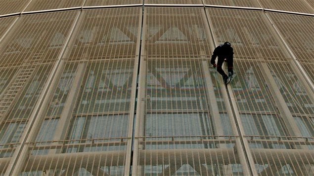 Le Français Alain Robert lors de son escalade à mains nues d'un hôtel de Doha en avril 2012 Le Français Alain Robert lors de son escalade à mains nues d'un hôtel de Doha en avril 2012