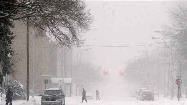 Des gens traversent la rue à Muskegon au Michigan le 7 février. Il neige depuis jeudi dans cette région. Des gens traversent la rue à Muskegon au Michigan le 7 février. Il neige depuis jeudi dans cette région.