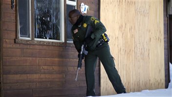 Un policier à la recherche de Christopher Dorner regarde à l’intérieur d’une maison de Big Bear Lake, en Californie. Un policier à la recherche de Christopher Dorner regarde à l’intérieur d’une maison de Big Bear Lake, en Californie.