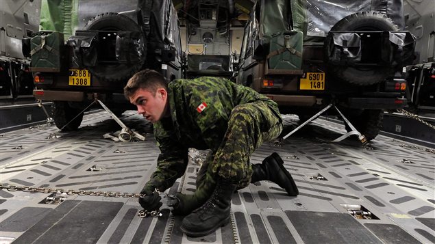 Un militaire canadien s'assure de bien immobiliser des jeeps français à l'intérieur de l'avion de transport CC-177 fourni par le Canada pour la mission au Mali. Un militaire canadien s'assure de bien immobiliser des jeeps français à l'intérieur de l'avion de transport CC-177 fourni par le Canada pour la mission au Mali.