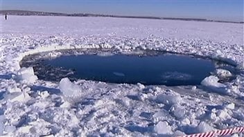 Le trou percé dans la glace d'un lac de l'Oural par un des débris de la météorite. L'objet a percé près d'une vingtaine de centimètres de glace. Le trou percé dans la glace d'un lac de l'Oural par un des débris de la météorite. L'objet a percé près d'une vingtaine de centimètres de glace.