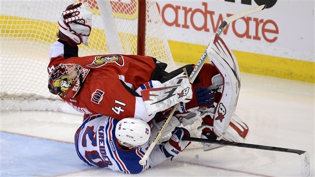 Craig Anderson des Sénateurs d'Ottawa est renversé par Chris Kreider. Craig Anderson des Sénateurs d'Ottawa est renversé par Chris Kreider.