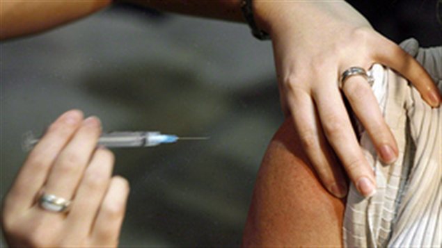 Une aiguille va injecter un vaccin dans le bras d'un patient Une aiguille va injecter un vaccin dans le bras d'un patient