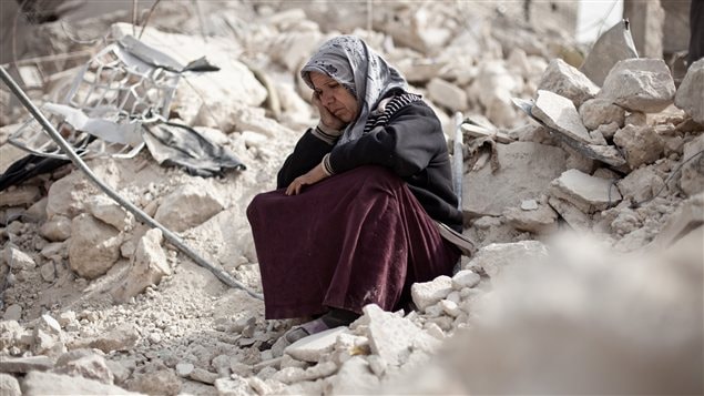 Une Syrienne d'Alep au milieu des ruines de son quartier bombardé Une Syrienne d'Alep au milieu des ruines de son quartier bombardé