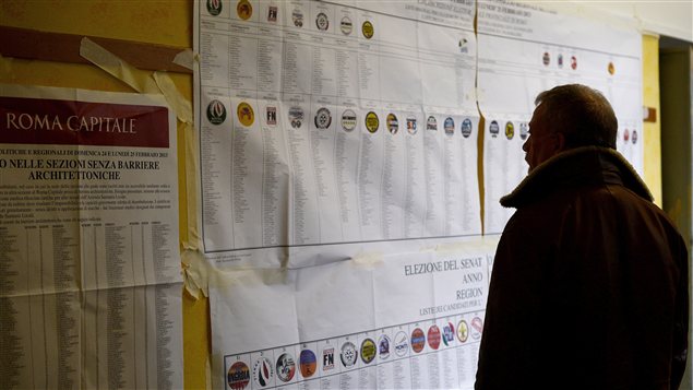 Un Italien regarde des informations sur les élections dans un bureau de vote, le 24 février. Un Italien regarde des informations sur les élections dans un bureau de vote, le 24 février.