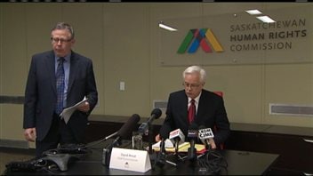 David Arnot, commissaire en chef de la Commission des droits de la personne de la Saskatchewan, est assis devant les micros David Arnot, commissaire en chef de la Commission des droits de la personne de la Saskatchewan, est assis devant les micros