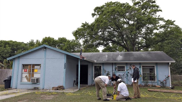 En Floride, des ingénieurs travaillent devant la maison au-dessous de laquelle s'est formé un gouffre qui a avalé un homme. En Floride, des ingénieurs travaillent devant la maison au-dessous de laquelle s'est formé un gouffre qui a avalé un homme.
