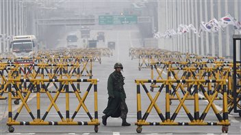 Un soldat de l'armée sud-coréenne patrouille sur le pont de Paju, près de la frontière entre les deux Corées. Un soldat de l'armée sud-coréenne patrouille sur le pont de Paju, près de la frontière entre les deux Corées.