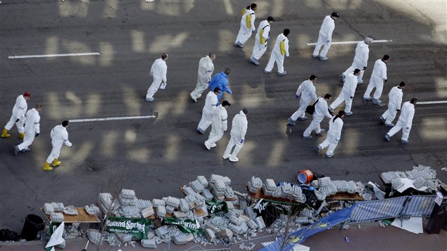Des agents scrutent un des sites de l'attentat de Boston. Des agents scrutent un des sites de l'attentat de Boston.