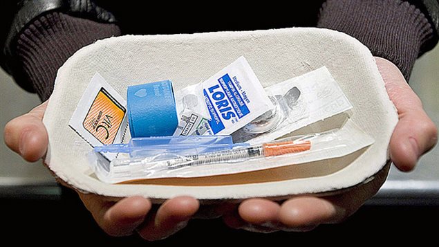 Un homme tient un nécessaire à injection supervisée de drogue. Un homme tient un nécessaire à injection supervisée de drogue.