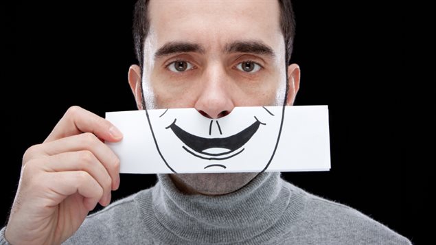 Un homme cache ses émotions derrière le dessin d'un sourire Un homme cache ses émotions derrière le dessin d'un sourire