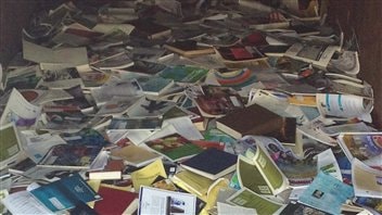 Des centaines de livres qui se retrouvent dans un conteneur à déchets dans la cour intérieure de l'IML Des centaines de livres qui se retrouvent dans un conteneur à déchets dans la cour intérieure de l'IML