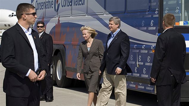 Le premier ministre Stephen Harper et sa femme protégés par des gardes du corps lors de la campagne électorale de 2008 Le premier ministre Stephen Harper et sa femme protégés par des gardes du corps lors de la campagne électorale de 2008