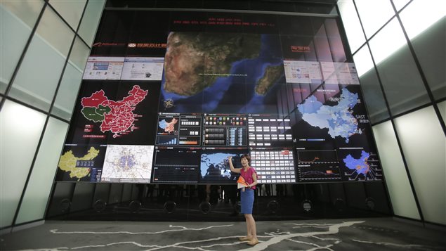 Une employée du géant local du commerce électronique Alibaba, basé en Chine, explique le fonctionnement de l'écran géant à l'entrée du siège social de l'entreprise. Une employée du géant local du commerce électronique Alibaba, basé en Chine, explique le fonctionnement de l'écran géant à l'entrée du siège social de l'entreprise.