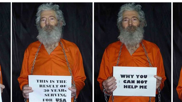 Des photos reçues par la femme de Robert Levinson en 2011 le montrent en tenue orange, tenant une pancarte sur laquelle on peut lire: "Pourquoi ne pouvez-vous m'aider?". On ignore où se trouve l'homme. Des photos reçues par la femme de Robert Levinson en 2011 le montrent en tenue orange, tenant une pancarte sur laquelle on peut lire: "Pourquoi ne pouvez-vous m'aider?". On ignore où se trouve l'homme.