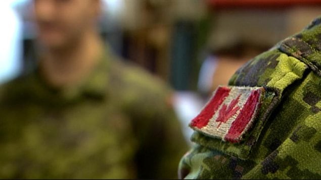 Un soldat porte l'uniforme avec le drapeau canadien sur l'épaulette, à la base d'Edmonton, le 6 mars 2014. Un soldat porte l'uniforme avec le drapeau canadien sur l'épaulette, à la base d'Edmonton, le 6 mars 2014.