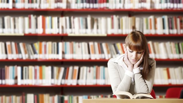 Femme lisant un livre dans une bibliothèque. Femme lisant un livre dans une bibliothèque.