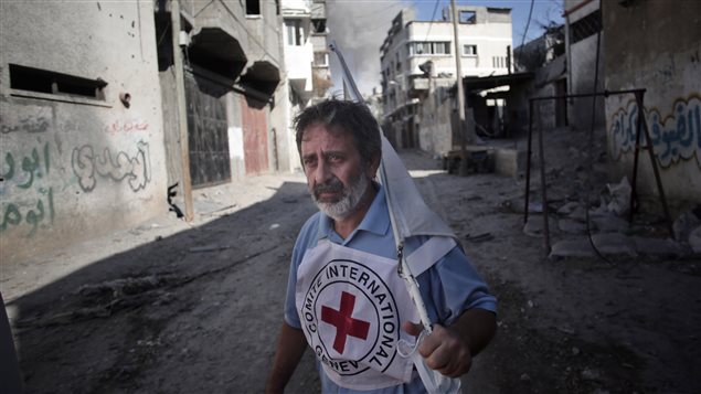 Un homme de la Croix-Rouge internationale brandit un drapeau blanc pendant l'évacuation. Un homme de la Croix-Rouge internationale brandit un drapeau blanc pendant l'évacuation.
