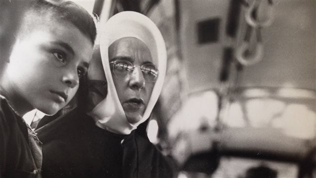Lida Moser : Une religieuse accompagnant un jeune garçon dans un autobus, à Montréal, été 1950, gélatine argentique, 17,6 x 18 cm (P728,DM3,P96) Lida Moser : Une religieuse accompagnant un jeune garçon dans un autobus, à Montréal, été 1950, gélatine argentique, 17,6 x 18 cm (P728,DM3,P96)
