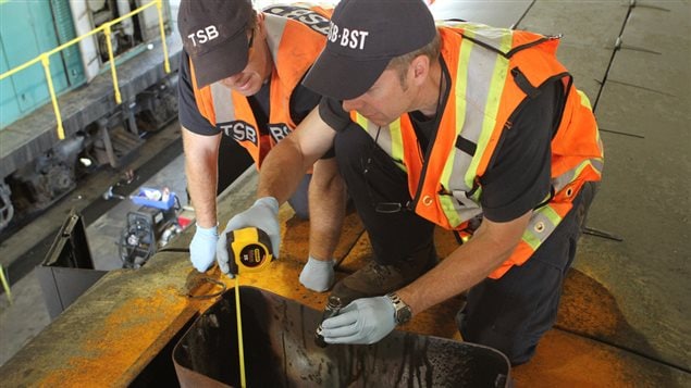 Des enquêteurs du Bureau de la sécurité dans les transports du Canada évaluent la cheminée de la locomotive de tête. Des enquêteurs du Bureau de la sécurité dans les transports du Canada évaluent la cheminée de la locomotive de tête.