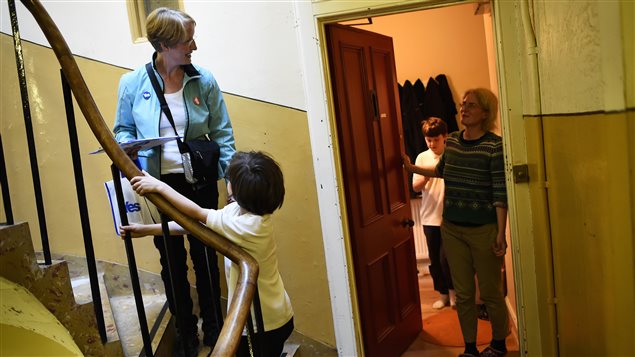 Une famille discute avec une volontaire qui fait campagne pour le Oui en Écosse. Une famille discute avec une volontaire qui fait campagne pour le Oui en Écosse.
