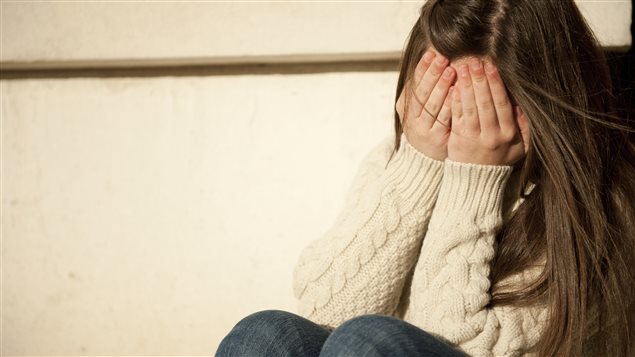 Une fille cache son visage dans ses mains. Une fille cache son visage dans ses mains.