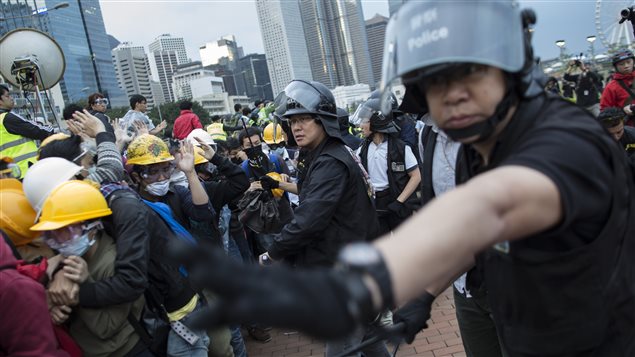 Des policiers tentaient de dégager la route Lung Wo, lundi. Des policiers tentaient de dégager la route Lung Wo, lundi.