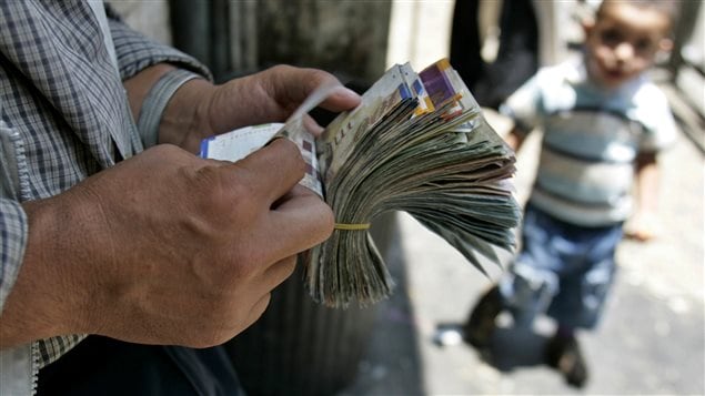 Un changeur palestinien compte ses billets dans une rue de Ramallah, en Cisjordanie. Un changeur palestinien compte ses billets dans une rue de Ramallah, en Cisjordanie.