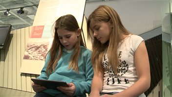 Deux élèves consultent l'application mobile du Musée de la Gaspésie. Deux élèves consultent l'application mobile du Musée de la Gaspésie.