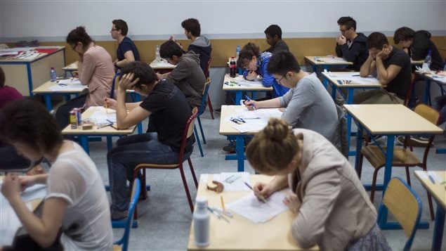 Des étudiants passent un examen dans une salle de classe. Des étudiants passent un examen dans une salle de classe.