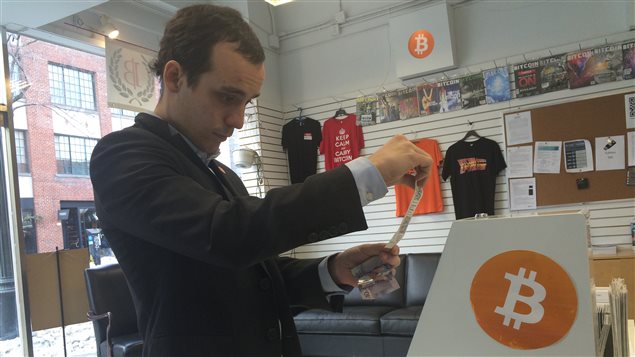 Francis Pouliot, directeur des affaires publiques de l'Ambassade Bitcoin à Montréal, insère un billet dans le guichet automatique afin d'acheter des bitcoins. Francis Pouliot, directeur des affaires publiques de l'Ambassade Bitcoin à Montréal, insère un billet dans le guichet automatique afin d'acheter des bitcoins.