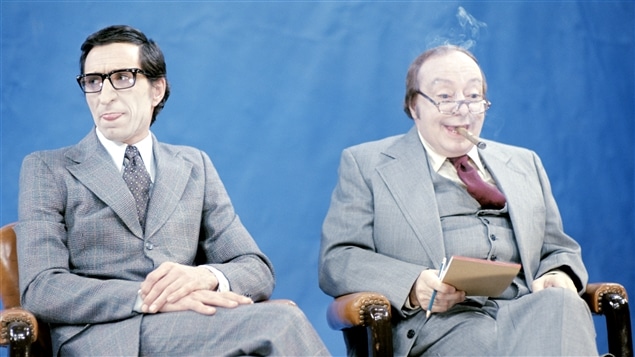 Image tirée d'un sketch du « Bye Bye 1976 ». Robert Bourassa (Benoît Marleau) et le conseiller de Robert Bourassa (René Caron). Image tirée d'un sketch du « Bye Bye 1976 ». Robert Bourassa (Benoît Marleau) et le conseiller de Robert Bourassa (René Caron).