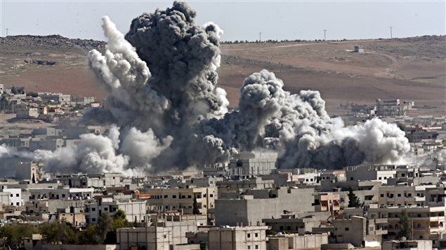 Cette photo datant du 22 octobre 2014 montre les résultats d’une attaque aérienne contre l’EI menée sur Kobani, en Syrie, par la coalition dirigée par les États-Unis. Cette photo datant du 22 octobre 2014 montre les résultats d’une attaque aérienne contre l’EI menée sur Kobani, en Syrie, par la coalition dirigée par les États-Unis.
