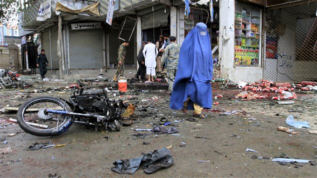 Une Afghane marche sur les lieux d'une attaque suicide à Jalalabad, qui a tué 33 personnes. Une Afghane marche sur les lieux d'une attaque suicide à Jalalabad, qui a tué 33 personnes.