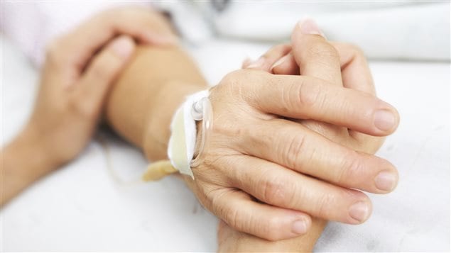 Une femme tient la main de sa mère à l'hôpital. Une femme tient la main de sa mère à l'hôpital.
