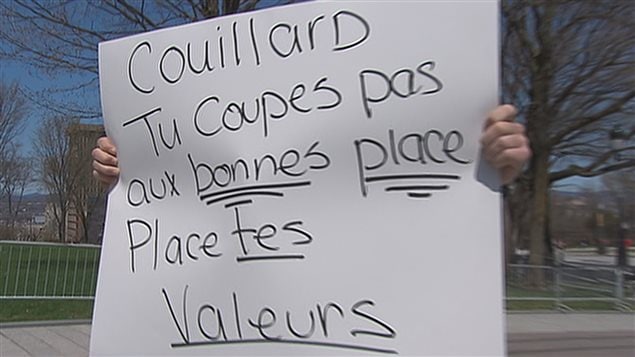 « Couillard, tu coupes pas aux bonnes places. Place tes valeurs », peut-on lire sur l'affiche d'un militant. (archives) « Couillard, tu coupes pas aux bonnes places. Place tes valeurs », peut-on lire sur l'affiche d'un militant. (archives)