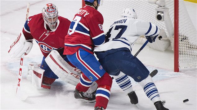 Carey Price se dresse devant Leo Komarov. Carey Price se dresse devant Leo Komarov.