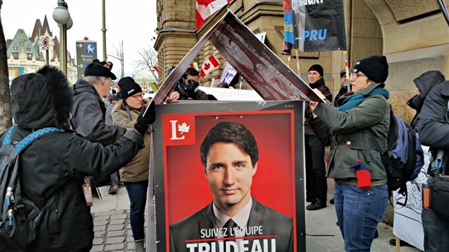 Des manifestants en train de construire une maison avec des pancartes électorales de Justin Trudeau. Des manifestants en train de construire une maison avec des pancartes électorales de Justin Trudeau.