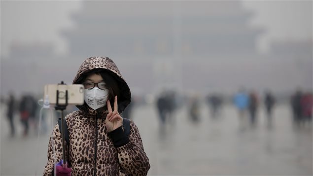 Un jeune femme se prend en photo lors d'une cérémonie à la place Tiananmen, à Pékin. Un jeune femme se prend en photo lors d'une cérémonie à la place Tiananmen, à Pékin.