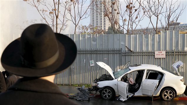 Un Israélien regarde l'automobile avec laquelle un Palestinien a foncé dans un arrêt d'autobus où attendaient de nombreuses personnes. Un Israélien regarde l'automobile avec laquelle un Palestinien a foncé dans un arrêt d'autobus où attendaient de nombreuses personnes.