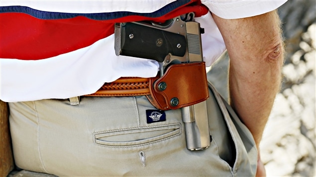 Cet homme porte un pistolet à la ceinture. Cet homme porte un pistolet à la ceinture.