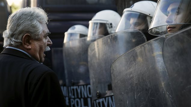 Le député grec Alkis Konstantindis confronte des policiers grecs lors d'une manifestation contre le projet de retraite du gouvernement. Le député grec Alkis Konstantindis confronte des policiers grecs lors d'une manifestation contre le projet de retraite du gouvernement.