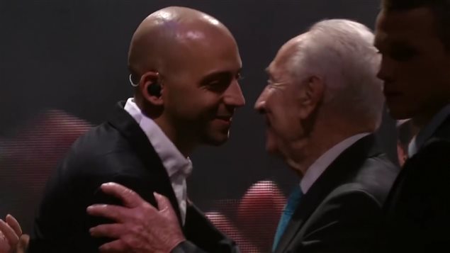 Concert à Tel-Aviv, le 5 février 2015. M. Shimon Peres, 9e président de l'État d'Israël, félicite Idan Raichel : « Un jour viendra ou nous traverserons le temps, passant de la guerre à la paix, et si quelqu'un ne sait pas comment faire, je lui montrerai le pont qu'Idan a construit. » Concert à Tel-Aviv, le 5 février 2015. M. Shimon Peres, 9e président de l'État d'Israël, félicite Idan Raichel : « Un jour viendra ou nous traverserons le temps, passant de la guerre à la paix, et si quelqu'un ne sait pas comment faire, je lui montrerai le pont qu'Idan a construit. »
