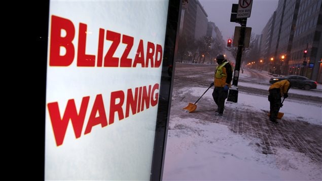 Des travailleurs commencent à nettoyer la neige qui tombe à Washington Des travailleurs commencent à nettoyer la neige qui tombe à Washington