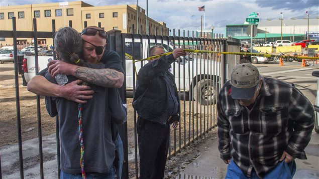 Des hommes s'enlacent pour se réconforter après la fusillade qui a éclaté samedi dans un amphithéâtre de Denver. Des hommes s'enlacent pour se réconforter après la fusillade qui a éclaté samedi dans un amphithéâtre de Denver.